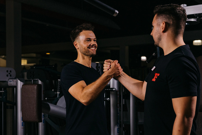 Zwei Teammitglieder von Fitness First beim Handschlag geben
