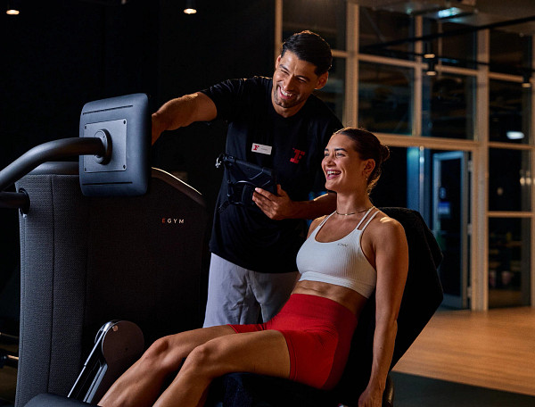 Fitness First Trainer unterstützt Frau beim EGYM Training