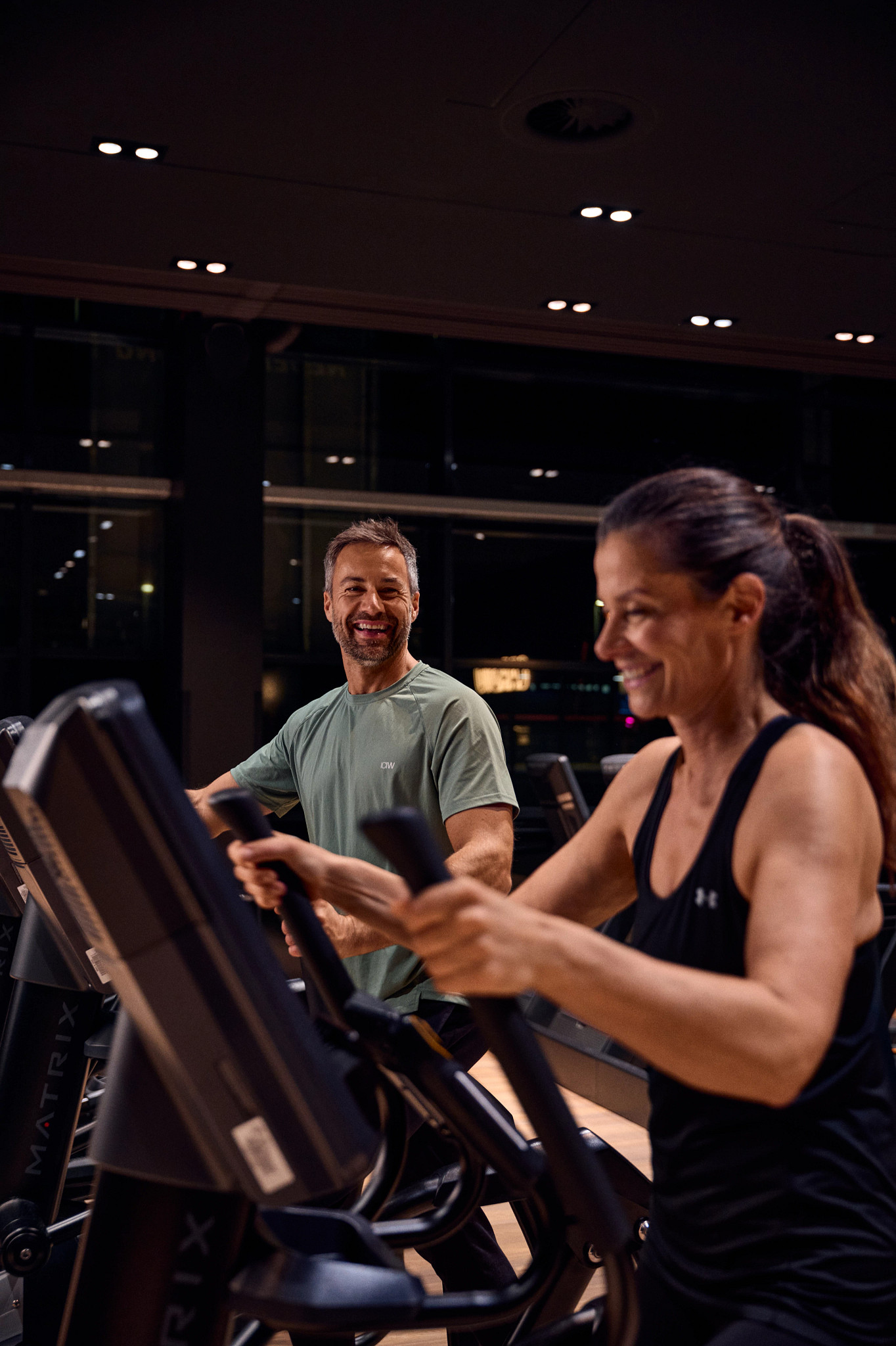 Frau und Mann trainieren an Cardiogeräten