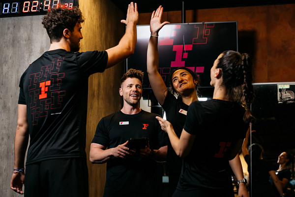 Gruppe Fitness First Trainer geben sich High Five